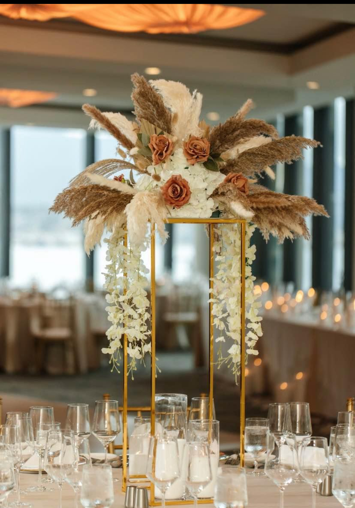 Gold tower centerpiece with pampas grass and rust roses