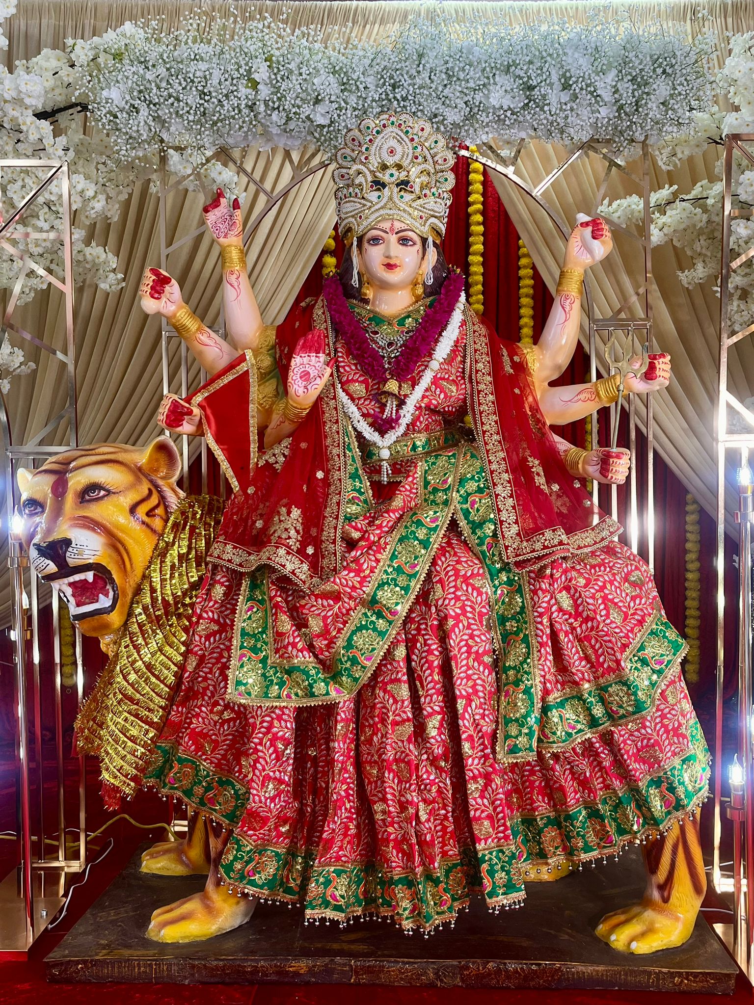 Mata Rani statue close-up with white floral arch